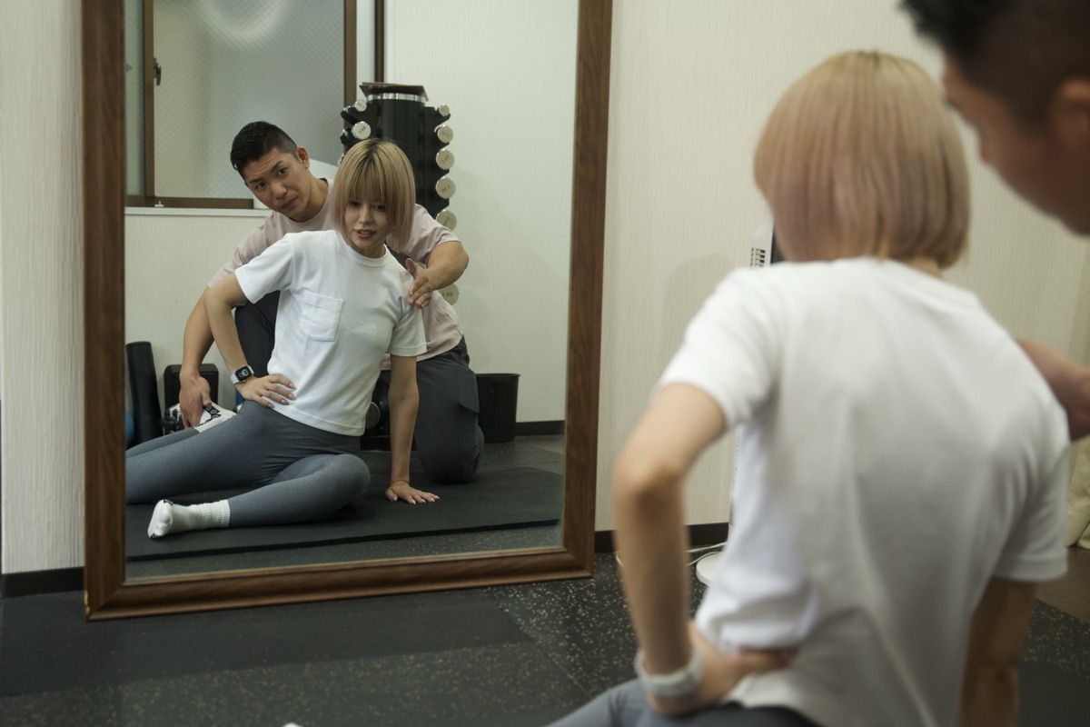 初心者に正しいフォームを指導するパーソナルトレーナー