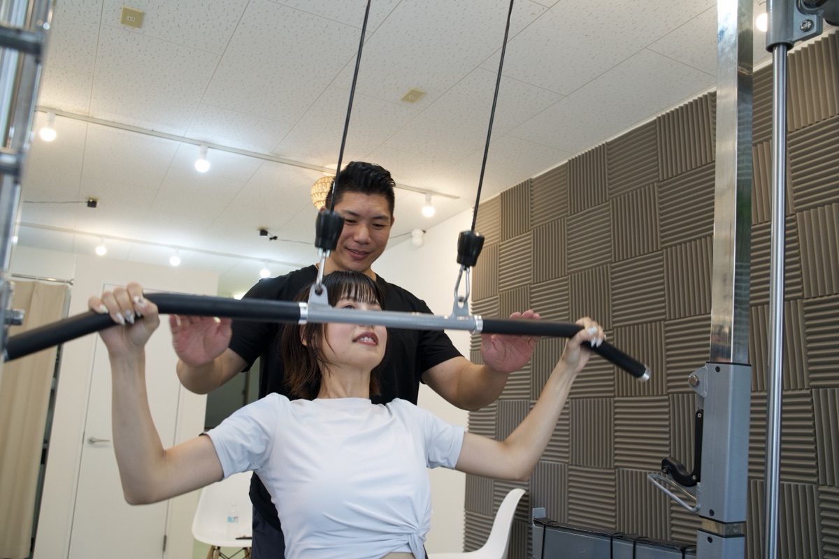 パーソナルジムで筋トレをする女性とトレーナー