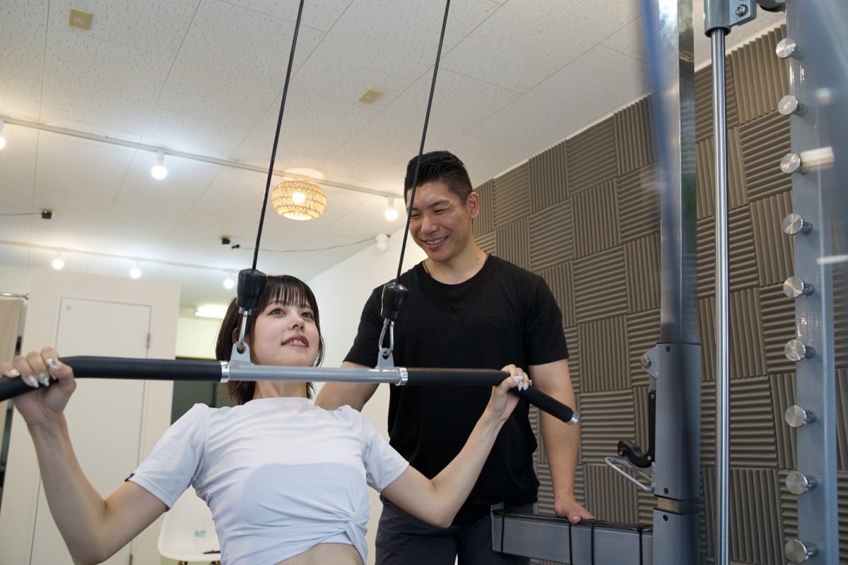 パーソナルジムでトレーニング指導を受ける女性