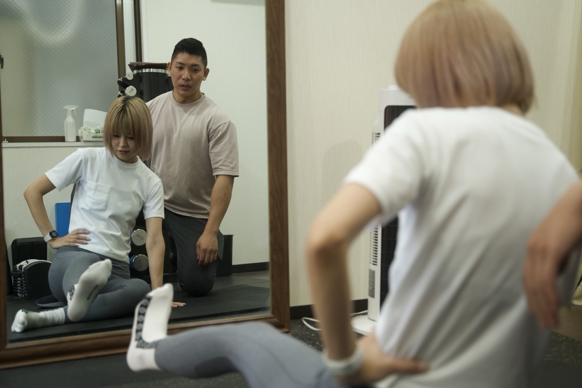 オフの日にストレッチを行う女性とパーソナルトレーナー