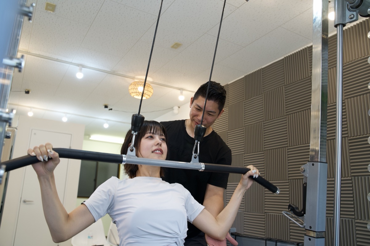 甲子園口のパーソナルジムでトレーナーがフォームを指導する様子