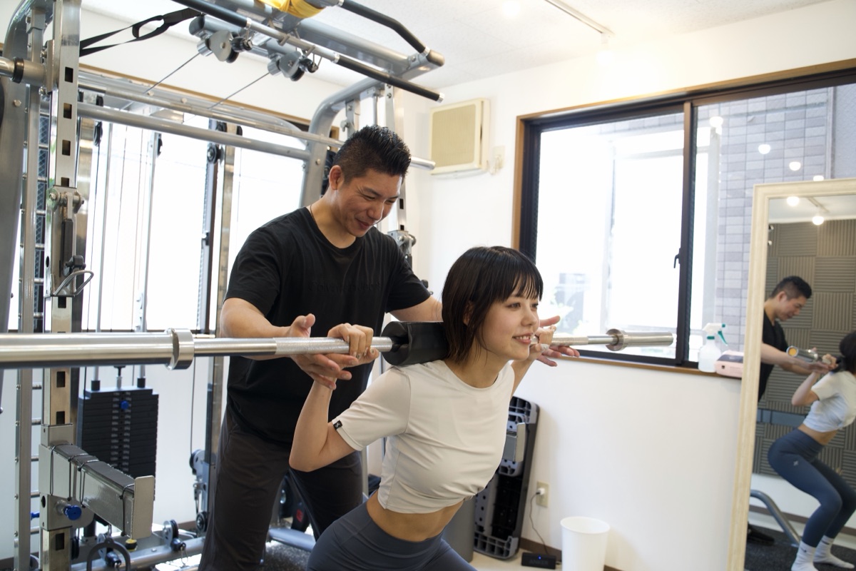 新開地のパーソナルジムでトレーナーの指導を受ける女性