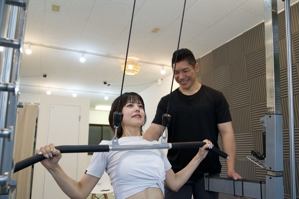 新長田のパーソナルジムでマシンの使い方を指導される女性