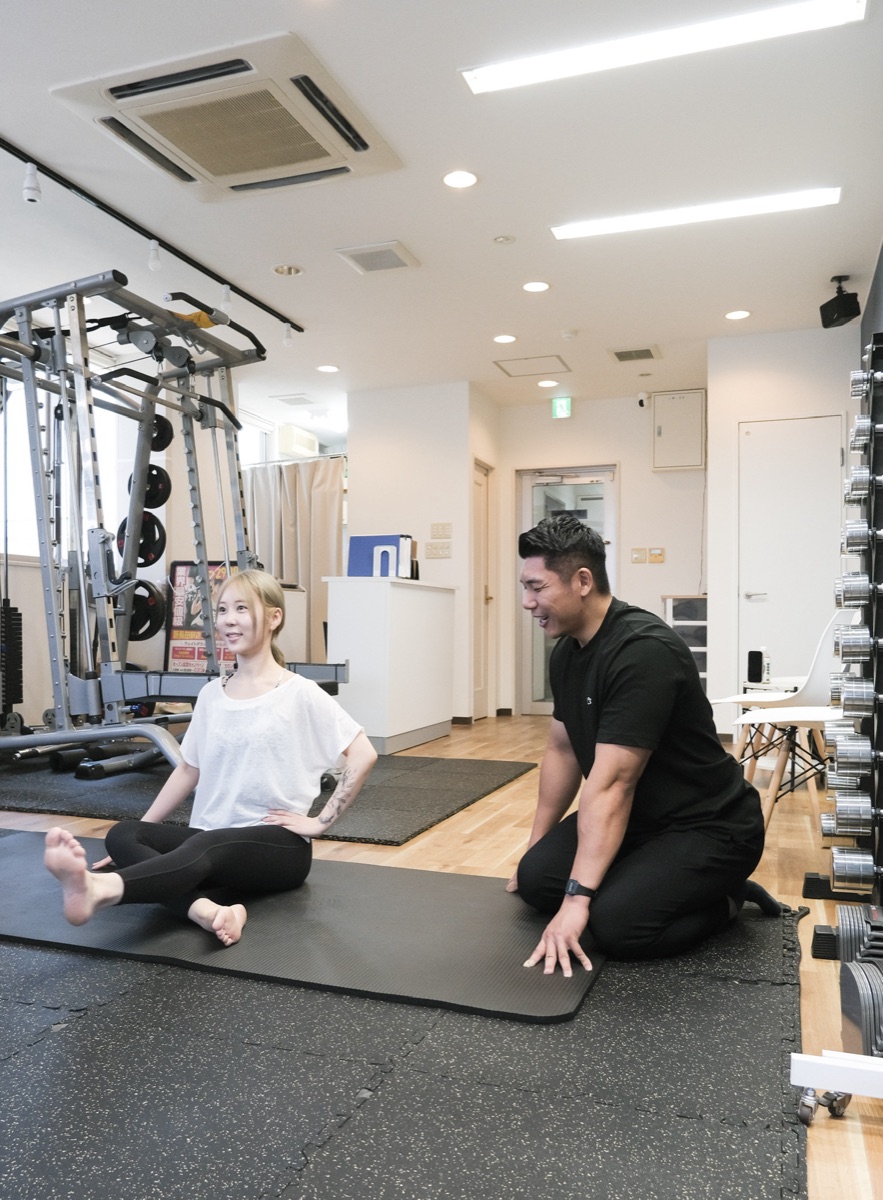 住吉のパーソナルジムでストレッチ指導を受ける女性とトレーナー