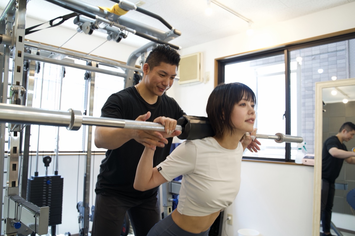 股関節を使うスクワットをトレーナーがマンツーマンで指導している様子