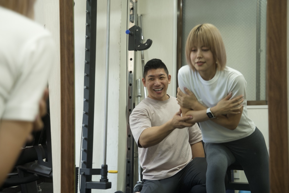 トレーナーが体幹トレーニングのフォームを指導する様子