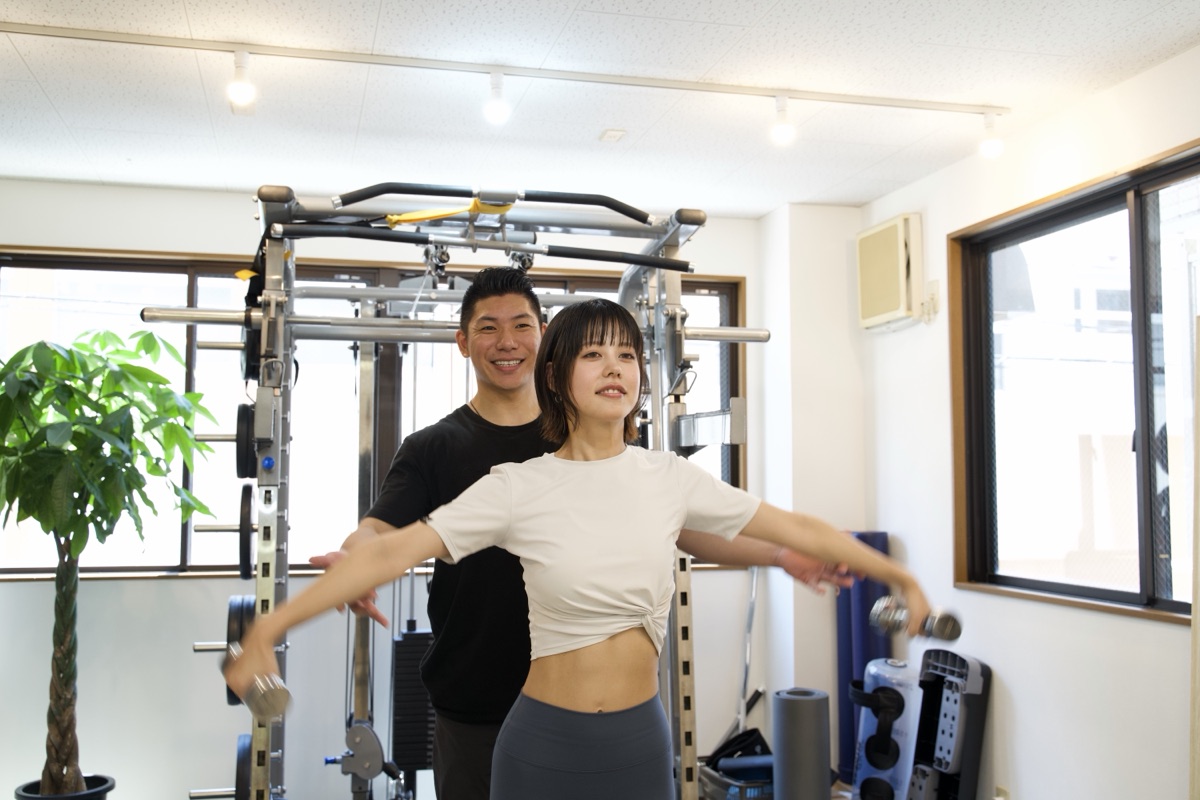 パーソナルジムでトレーナーがフォームを確認している様子