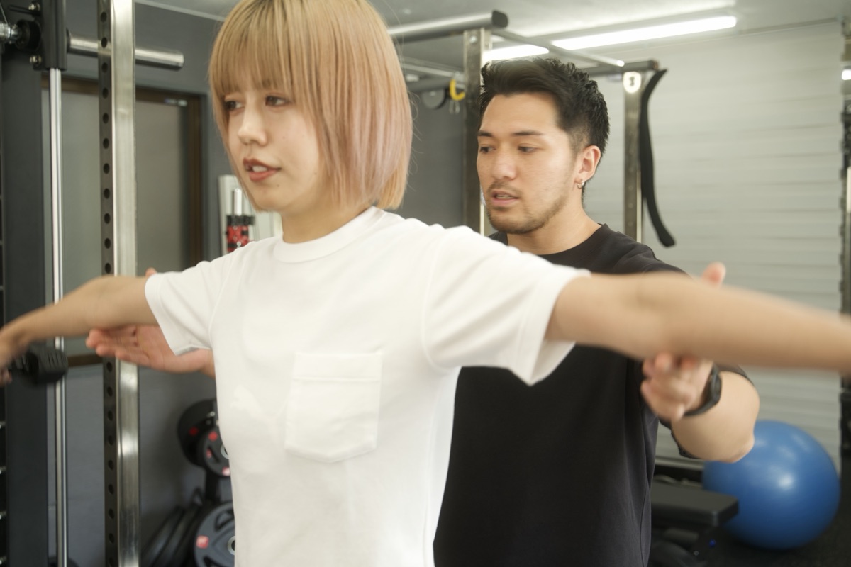 摂津本山のパーソナルジムでトレーナーが腕の動きを確認しながら指導する様子