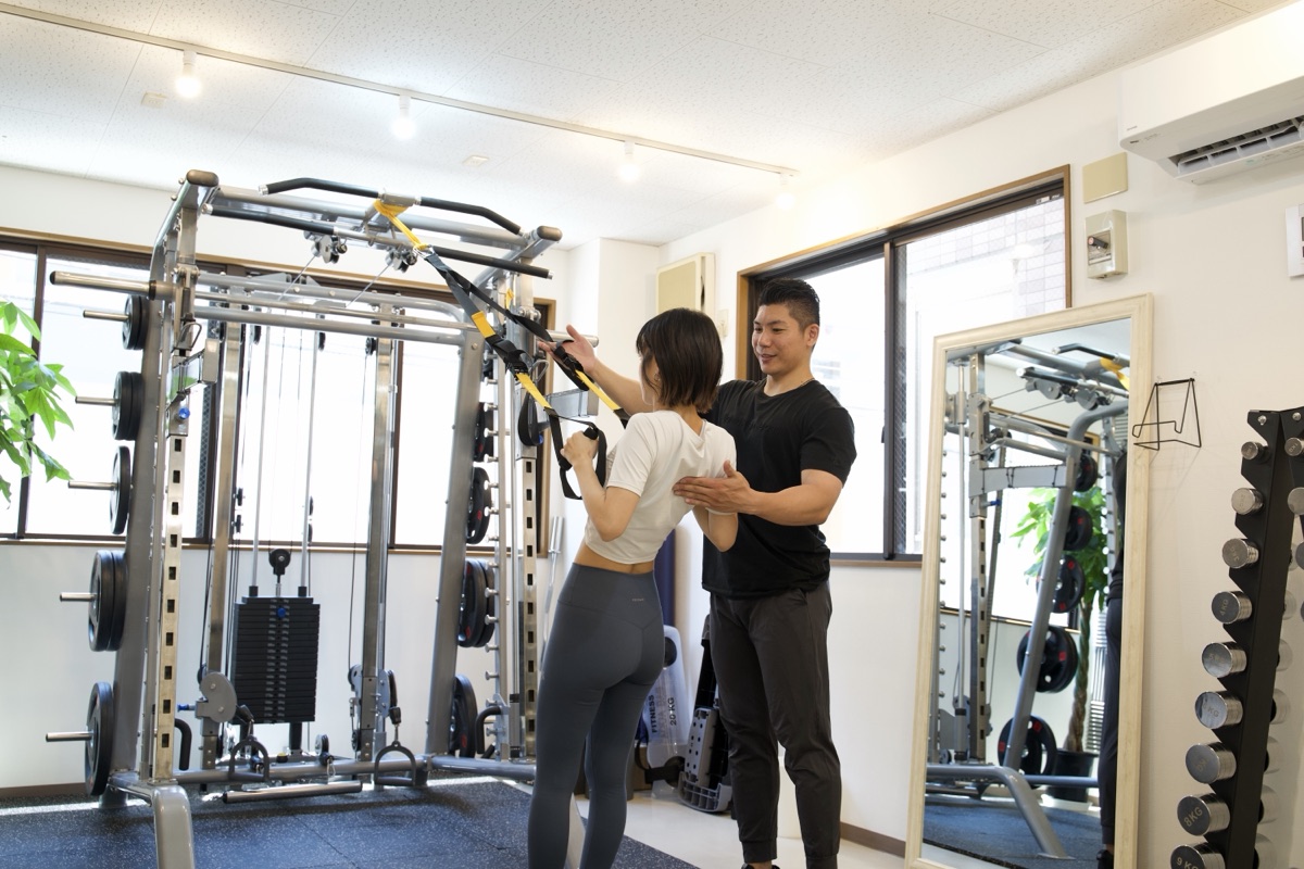 摂津本山・岡本のパーソナルジムで姿勢を確認しながらトレーニングする女性とトレーナー