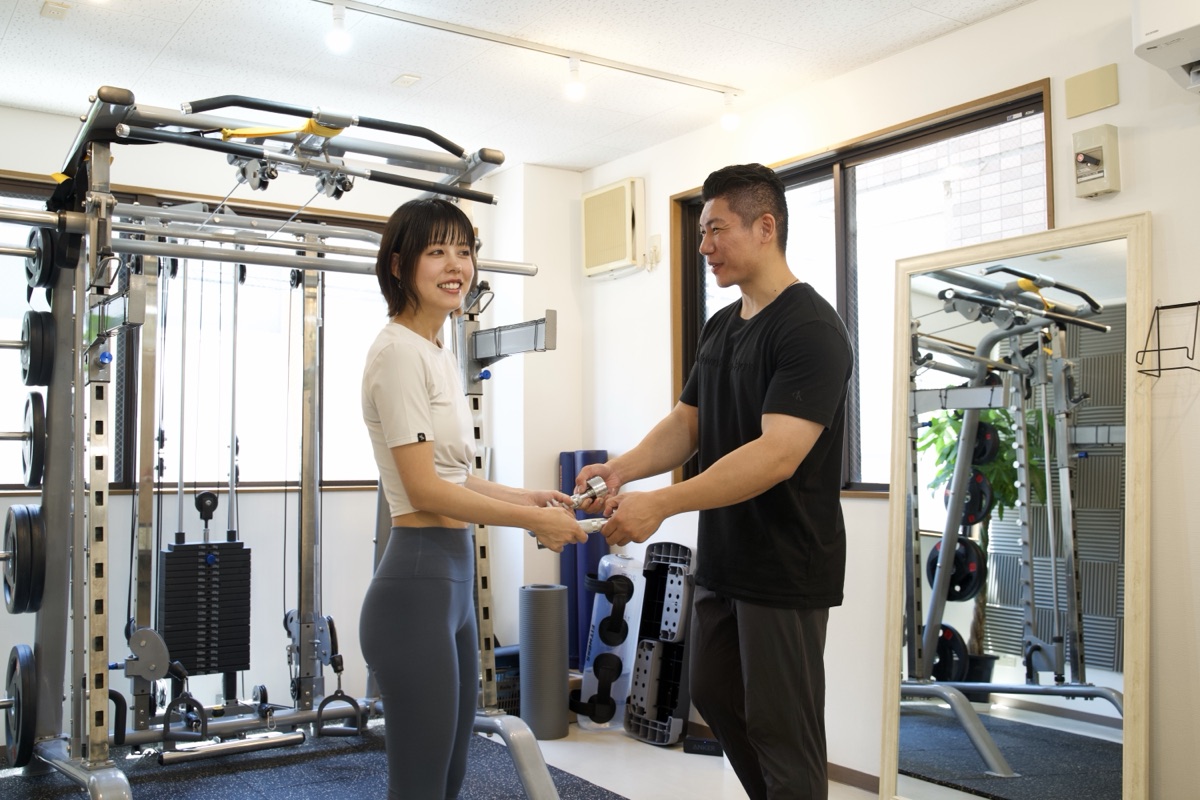 西宮から通えるパーソナルジムで姿勢をチェックするトレーナー